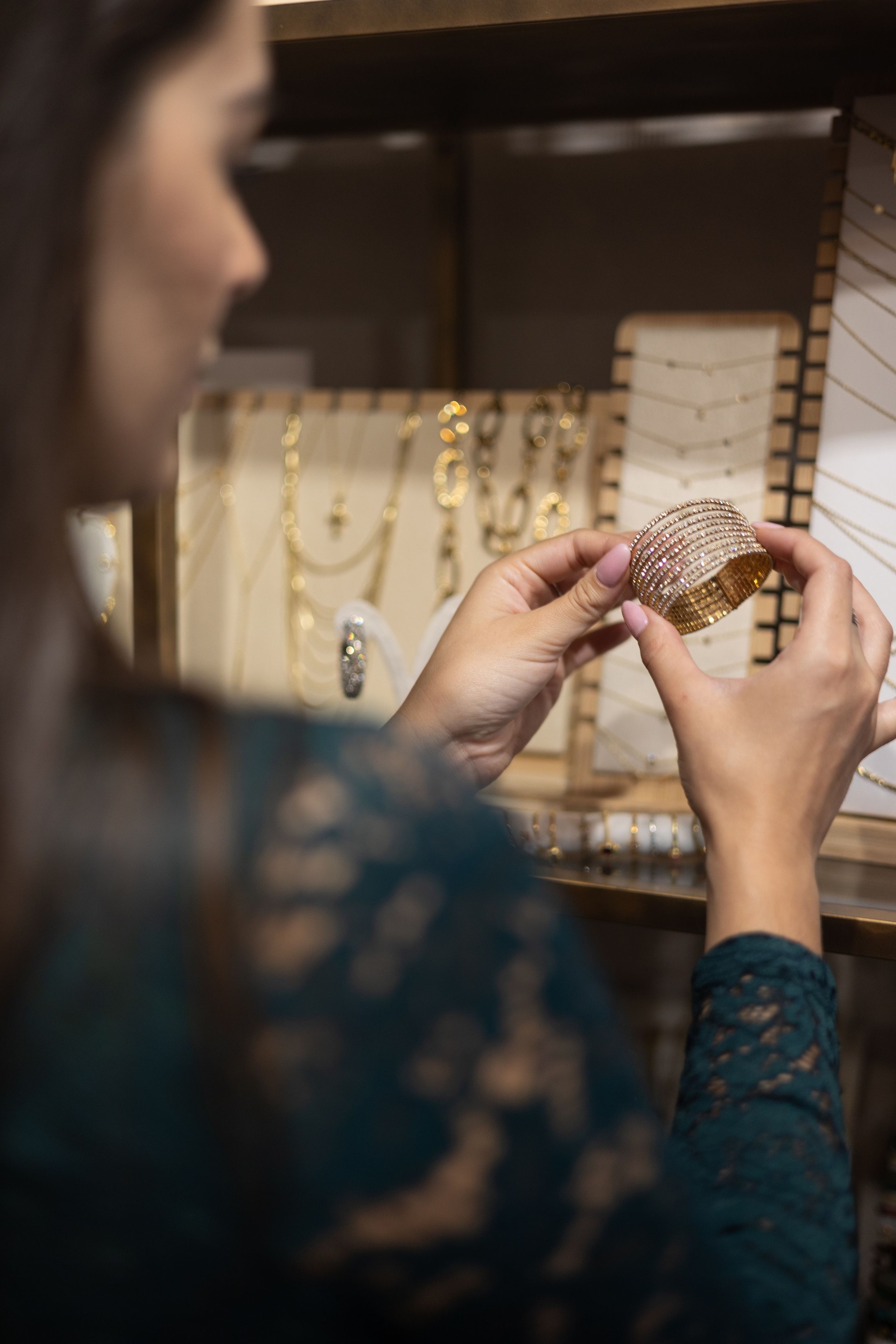 Customer selecting a crystal bracelet at a jewelry store, shopping concept